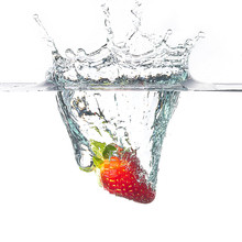 Single Red Strawberry Splashing On Water In A White Background