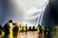 Blurred Out Tourists Experiencing Niagara Falls From The Side
