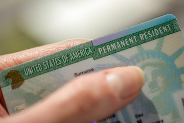 Close up view of Permanent resident card (Green) card of USA on blurred background.