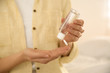 © New Africa - Woman applying antiseptic gel on blurred background, closeup