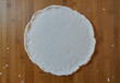Fresh round homemade thin pizza dough crust on floured wooden board made with a gluten-free flour. top view