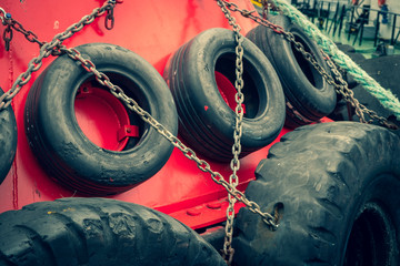 Old car tires on board a ship. Rubber wheels protect the boat from impact. Steel lining of the side of the tugboat.