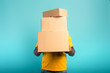 © alphaspirit - Man is hidden by too many received packages. Cyan background