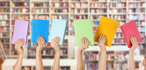 Wall Mural - Female hands with books in modern library