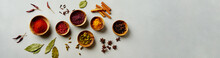 Various Colorful Spices In Wood Bowls On Concrete Background. Top View With Copy Space. Different Pepper, Turmeric, Paprika, Rosemary, Chilly, Cardamom, Cinnamon, Anise, Cloves.