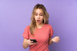 © luismolinero - Teenager Russian girl isolated on purple background surprised and sending a message