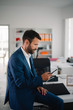 © JustLife - Businessman in office. Handsome man using the phone.