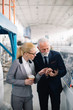 © JustLife - Colleagues working on project. Team of architects discussing business in factory.