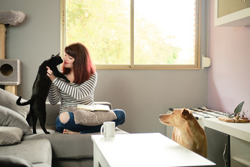 Girl working with her cat and dog
