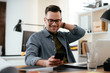 © JustLife - Businessman in office. Handsome man using the phone at work