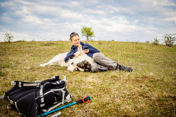 Wall Mural - woman and dog enjoying outdoors on a green field