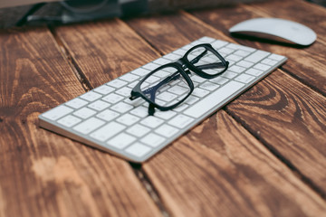 Poster - Glasses for sight and vision correction and protection from computer on the wooden table on the keyboard