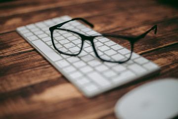 Glasses for sight and vision correction and protection from computer on the wooden table on the keyboard