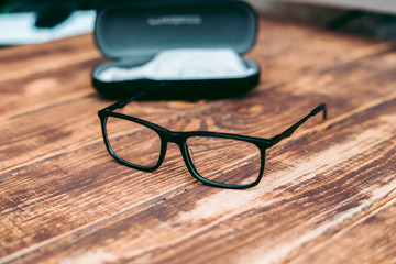 Poster - Glasses for sight and vision correction and protection from computer with ptotection case on the wooden table