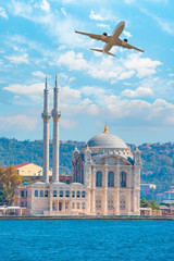 Airplane flying over Ortakoy Mosque  - Istanbul, Turkey