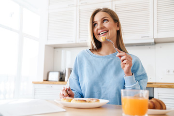 Sticker - Image of cheerful young woman smiling while having breakfast