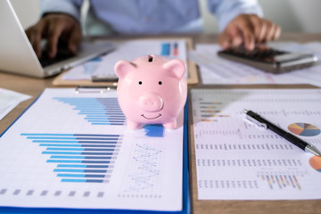 Wall Mural - Man Usingcalculator with money stack Financial Report- Business Accounting Concept accounting money with statistics graphs