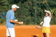 © Microgen - Tennis instructor with senior woman, tennis training lesson