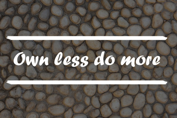 Wall Mural - Inspirational Quote on a stone background - Own Less do more