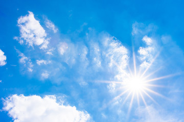 beautiful, blue summer sky with fluffy clouds and bright sun as a background