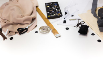 Sewing accessories and fabric on a white background. Sewing threads, needles, pins, fabric, buttons and sewing centimeter. top view, flatlay