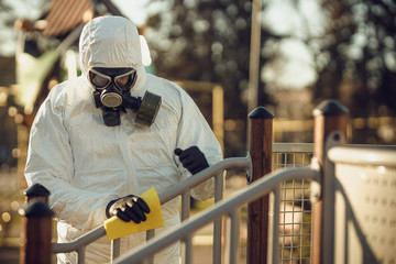 Wall Mural - Cleaning and Disinfection on the playground in the sity complex amid the coronavirus epidemic Teams for disinfection efforts Infection prevention and control of epidemic Protective suit and mask