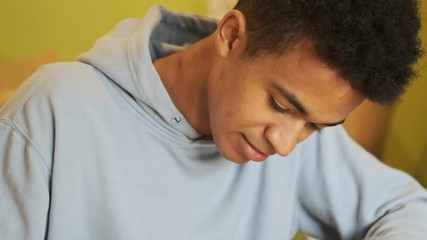 Poster - Concentrated  handsome african guy student studying doing homework writing notes.