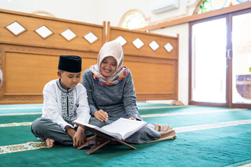 kid learning to read quran with muslim teacher or ustad