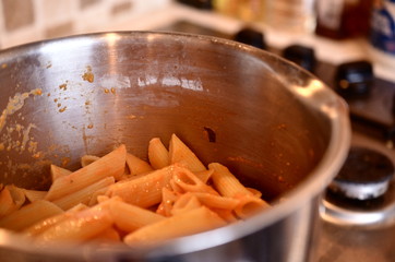 A saucepan of freshly cooked pasta on a gas stove ready for dinner