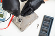 © andrey - Computer Hard Drive. removes seal. black gloves