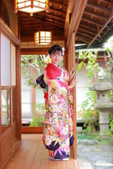 Attractive girl wearing traditional japanese kimono in Japanese-style garden in kyoto, Japan.