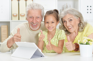 Sticker - Portrait of grandparents with granddaughter using tablet