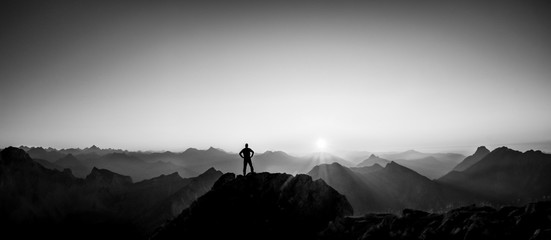 Poster - Man reaching summit enjoying freedom and looking towards mountains sunset.