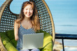 happy asian freelancer businesswoman using a laptop in summer vacation on beach tropical resort.freelance and remote work concept on sea
