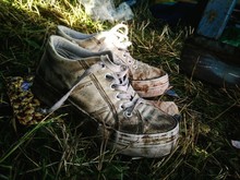 Close-up Of Old Dirty Shoes On Field