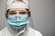 © fesenko - Close-up of woman in protective clothes with shield and medical mask.