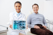 © LIGHTFIELD STUDIOS - selective focus of cheerful african american dentist holding digital tablet with medical app on screen near happy patient