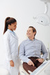 © LIGHTFIELD STUDIOS - happy patient looking at smiling african american dentist in braces