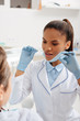 © LIGHTFIELD STUDIOS - selective focus of attractive african american dentist in latex gloves holding dental floss near patient