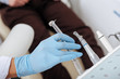 © LIGHTFIELD STUDIOS - cropped view of dentist taking stainless dental instrument near patient