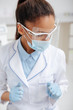 © LIGHTFIELD STUDIOS - african american dentist in medical mask, face shield and latex gloves