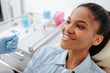 © LIGHTFIELD STUDIOS - orthodontist in holding dental instruments near happy african american patient in braces
