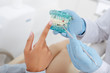 © LIGHTFIELD STUDIOS - cropped view of african american woman pointing with finger at teeth model with caries near dentist in latex gloves