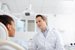 © LIGHTFIELD STUDIOS - selective focus of dentist looking at african american patient