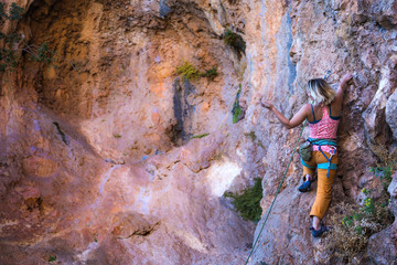 Wall Mural - A girl climbs a rock.