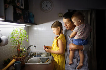 Wall Mural - Dad and children wash dishes in sink, together