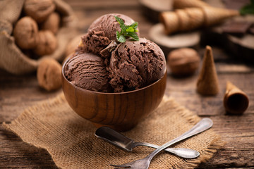 Wall Mural - Bowl of chocolate and hazelnut ice cream on wooden table