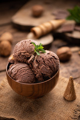 Wall Mural - Bowl of chocolate and hazelnut ice cream on wooden table