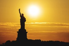 Silhouette Statue Of Liberty Against Orange Sky During Sunset