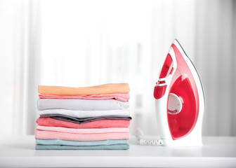 Wall Mural - Stack of colorful cotton clothes with iron.Household concept.Stacked laundry.
